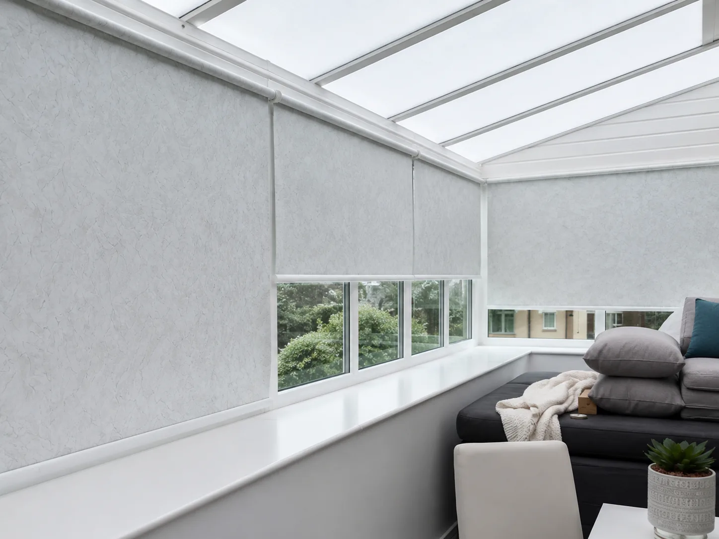 Light patterned roller blinds fitted around a bright conservatory