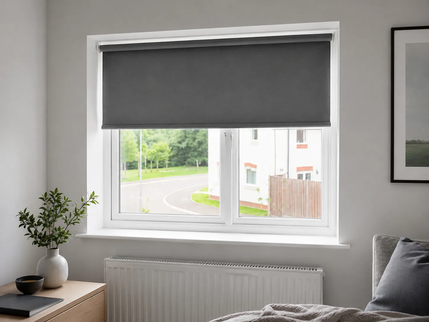 Dark grey roller blind fitted to a bedroom window