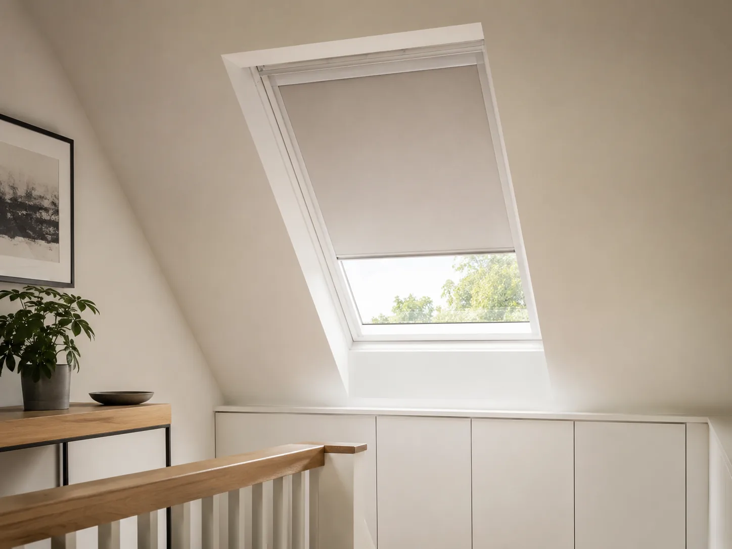 Light blind partially lowered over a roof window in a modern loft landing