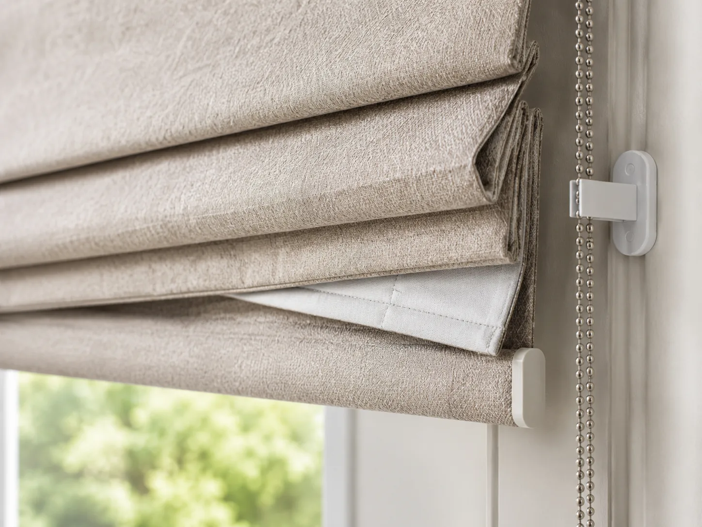 Close view of a neutral Roman blind with a secured operating chain