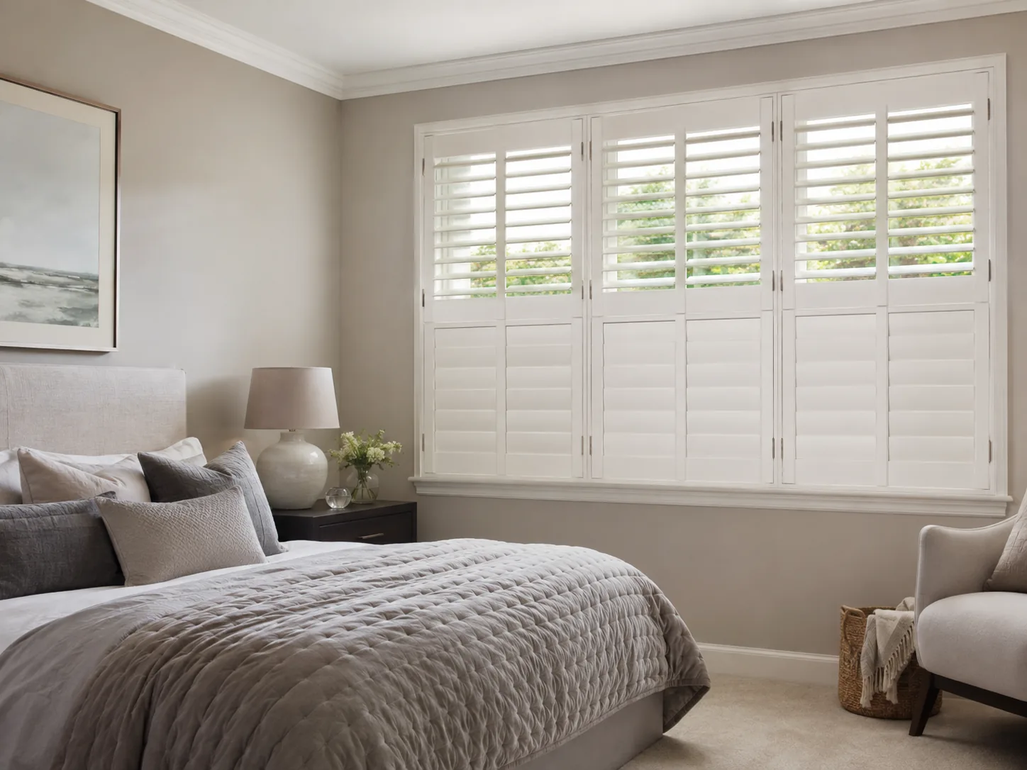 White tier-on-tier shutters fitted across a wide bedroom window