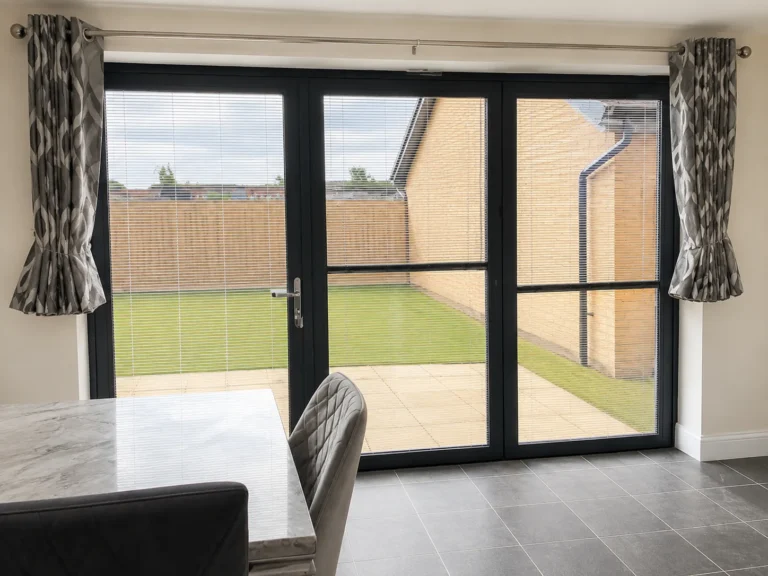 Slim fitted Venetian-style blinds installed on black-framed glazed doors