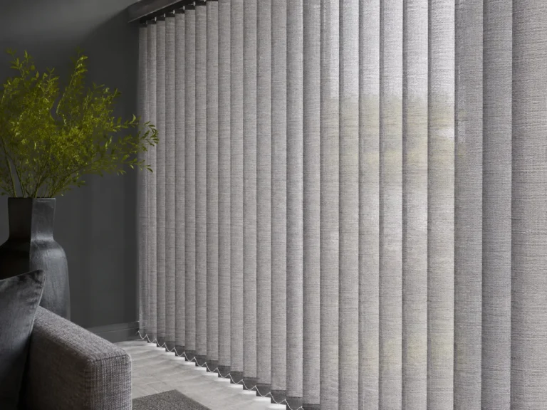 Close view of grey textured vertical blind slats filtering daylight